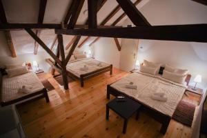 an attic room with two beds and a table at Epicenter in Niš