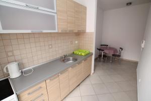 a kitchen with a sink and a table at Apartman Katja in Herceg-Novi