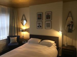 a bedroom with a white bed and a blue chair at Studio Apartment, Covent Garden in London