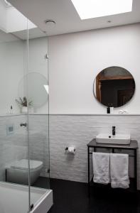 a bathroom with a sink and a toilet and a mirror at Heritage House in Stellenbosch