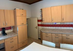 une cuisine vide avec des armoires et des comptoirs en bois dans l'établissement Einfamilienhaus Garbsen Havelse, à Garbsen