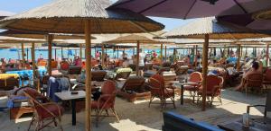 a beach with many chairs and tables and umbrellas at Apartment Radosevic in Olympic Beach