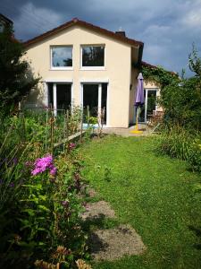 a house with a yard with flowers in front of it at Sunny Loft Haus RV in Ravensburg