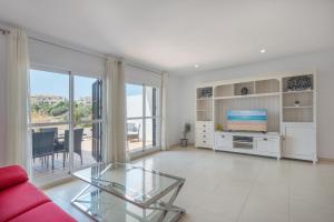 a living room with a red couch and a television at Sea Flower Miraflores Golf and Beach Parking included in La Cala de Mijas