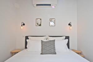 a bedroom with a bed with white sheets and pillows at Vila Olarias in Lisbon
