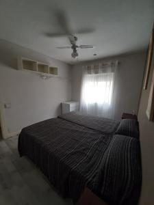 een slaapkamer met een bed en een plafondventilator bij Casa aragon in Boadilla del Monte