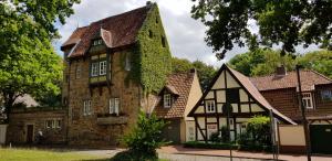 an old house with ivy on the side of it at Gästewohnung Wasserzucht in Wunstorf