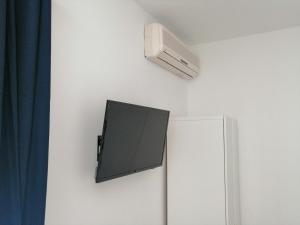 uma televisão de ecrã plano numa parede ao lado de um frigorífico em Studio apartman Adris em Sibenik