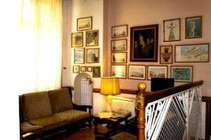 uma sala de estar com uma cadeira e quadros na parede em Acropolis House em Atenas