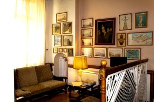 a living room with a chair and pictures on the wall at Acropolis House Hotel Classic in Athens