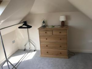 a room with a dresser with a lamp and a dresser at The Old Stable. Coombelands in Brighton & Hove