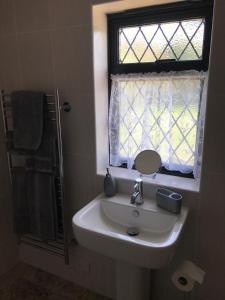 a bathroom with a sink and a window at The Old Stable. Coombelands in Brighton & Hove