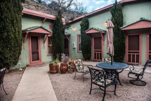 a patio with a table and chairs and an umbrella at Jonquil Motel in Bisbee