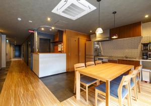 Il comprend une cuisine et une salle à manger avec une table et des chaises en bois. dans l'établissement Guest House Goettingen, à Kyoto