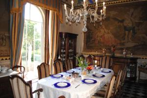 een eetkamer met een tafel en een kroonluchter bij B&B Castello Machiavelli in Ozzano dell Emilia