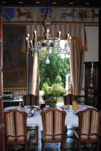 een eetkamer met een tafel en stoelen en een kroonluchter bij B&B Castello Machiavelli in Ozzano dell Emilia