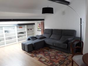 a living room with a gray couch and a rug at Coro in Villaviciosa