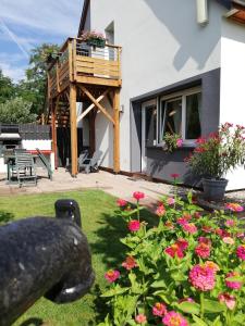 ein Haus mit einem Balkon und Blumen im Hof in der Unterkunft Au Petit Bonheur Charmant Gite Colmar in Horbourg