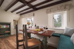 un comedor con una mesa con copas de vino y un sofá en Crow Hall - Luxury Holiday Accommodation, en Reeth