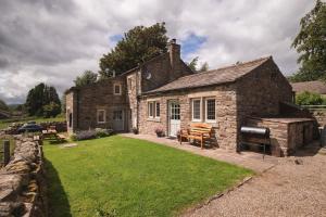 una antigua casa de piedra con un gran patio en Crow Hall - Luxury Holiday Accommodation, en Reeth