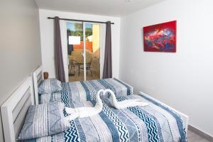 sypialnia z 2 łóżkami z niebieską i białą pościelą w obiekcie La Aldea w mieście Santo Domingo