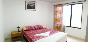 een kleine slaapkamer met een bed en een raam bij Hospedaje La Pradera 3 y 7 días -OFF in Jamundí