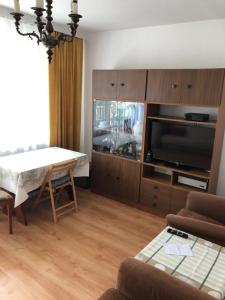 a living room with a flat screen tv and a table at Pułaskiego 13/17 m.6 Apartament in Gdańsk