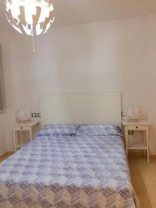 łóżko w sypialni z dwoma stołami i żyrandolem w obiekcie Apartamentos Deluxe Roquetas de Mar con Golf y Piscina Climatizada, Parking privado w mieście Vícar