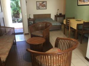 a room with chairs and a bed and a table at Résidence les cactus in Noumea