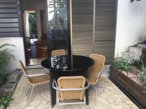 einen schwarzen Tisch und Stühle auf einer Terrasse in der Unterkunft Résidence les cactus in Noumea