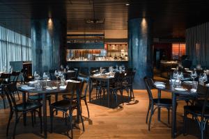 a restaurant with tables and chairs and a bar at Shadow Play by Peppers in Melbourne