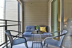 een veranda met 2 stoelen, een tafel en een bank bij GA Living Suites - Knox District Uptown Dallas in Dallas