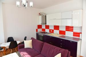 uma sala de estar com um sofá roxo numa cozinha em gzim's apartment em Durrës