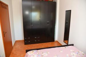 a bedroom with a bed and a black cabinet at gzim's apartment in Durrës