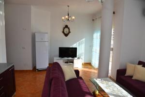 a living room with a couch and a tv at gzim's apartment in Durrës