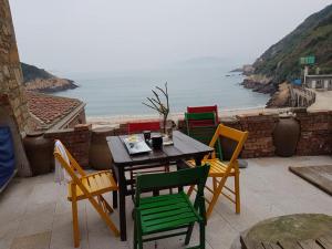 a table and chairs with a view of the ocean at Eternal Seaside House in Nangan