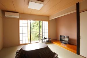a living room with a large window and a tv at Hakone Fura in Hakone