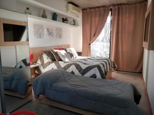 1 dormitorio con 2 camas y ventana en DEPARTAMENTO VERA MUJICA 1 cochera propia incluida en Rosario