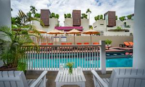 a resort pool with chairs and tables and umbrellas at Loligo Resort Hua Hin in Hua Hin