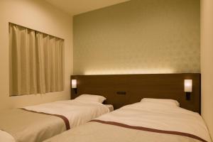 Postel nebo postele na pokoji v ubytování Tosei Hotel Cocone Ueno