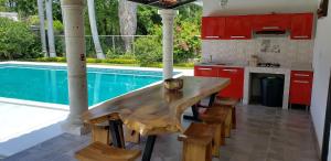 Ticumán的住宿－Casa cerca de las Estacas，一个带木桌的厨房,位于游泳池旁