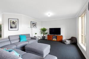 ein Wohnzimmer mit einem Sofa und einem TV in der Unterkunft Maggie's Place in Mount Gambier