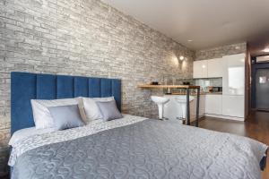 a bedroom with a large bed and a brick wall at Apartments Home Hotel in Yekaterinburg
