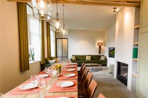 een eetkamer met een lange tafel met wijnglazen bij Landhuis Eikenburg in Ieper