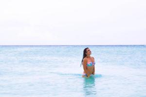 Una mujer en bikini parada en el océano en Shallow Lagoon Rasdhoo, en Rasdu