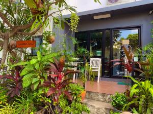 a porch with chairs and plants in front of a house at KoHabitat Samui in Bophut 