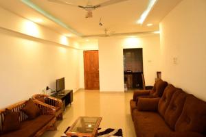 sala de estar con 2 sofás y TV en 3 BHK Apartment with river view, en Panaji