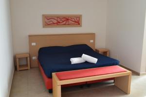 a bedroom with a blue bed with two pillows on it at Mon Rêve Resort in Taranto