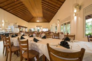comedor grande con mesas y sillas blancas en Sungreen Resort en Habarana