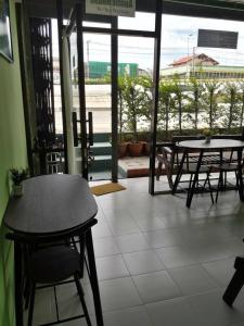 a room with tables and chairs and a view of an airport at Auntie House985 in Phra Nakhon Si Ayutthaya +37 photos